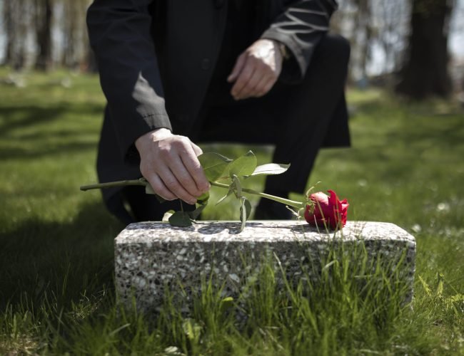 man-bringing-rose-tombstone-cemetery